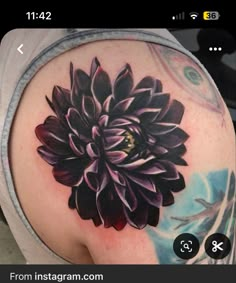 a black and white flower on the back of a woman's shoulder