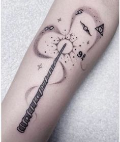 a harry potter wand tattoo on the right arm and leg, with stars around it