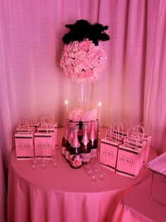 a table with pink flowers and candles on it