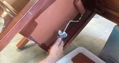 a person using a hammer to paint a wooden table