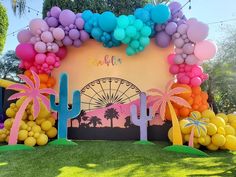 an outdoor area decorated with balloons and palm trees