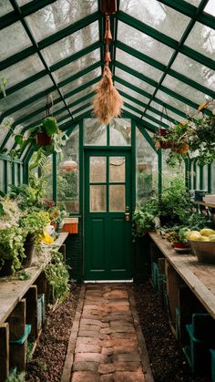 the inside of a green house with lots of plants and flowers hanging from it's ceiling