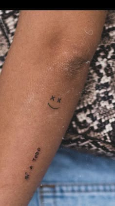 a woman's arm with a small star and moon tattoo on the left forearm