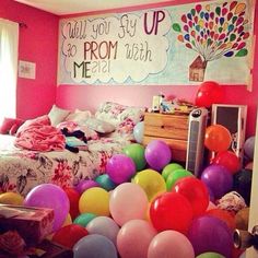 a bedroom with balloons all over the floor and a sign on the wall that says, what you say up to prom with me