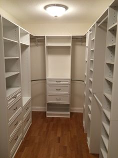 an empty walk in closet with drawers and shelves