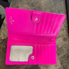 a pink wallet sitting on top of a table