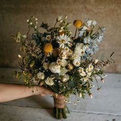 a person holding a bouquet of flowers in their hand