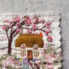 a piece of fabric with flowers and a house on it