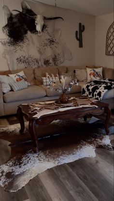 a living room filled with furniture and cow skin rugs on the floor next to a couch