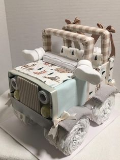 a cake made to look like a jeep with baby blankets on the hood and wheels