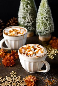 two white cups filled with hot chocolate and marshmallows