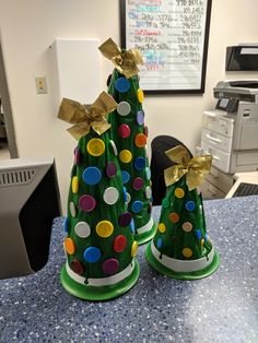 two plastic christmas trees sitting on top of a table