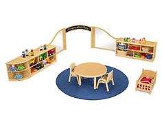 a wooden table and chairs in front of a bookshelf filled with children's toys