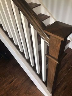 a wooden stair rail with white railings