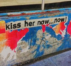 a sign on the side of a building that says, kiss her now how?