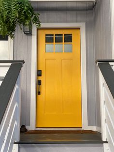 a yellow front door on a gray house