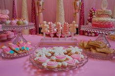 a pink table topped with lots of desserts