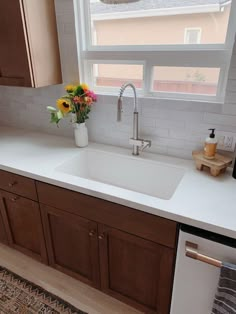 a white kitchen sink sitting under a window