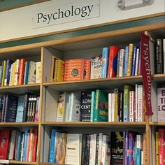 a book shelf filled with lots of books next to a sign that says psychology