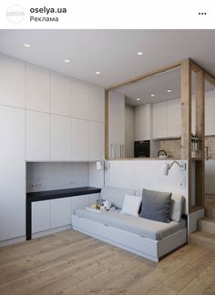 a living room filled with furniture and white walls on top of a hard wood floor