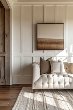 a white couch sitting in the middle of a living room next to a wooden wall