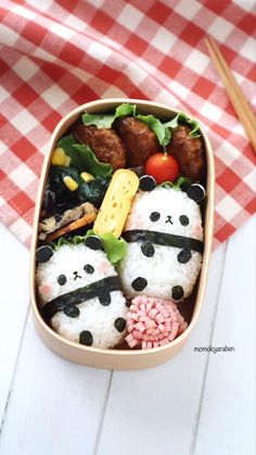 a bento box filled with rice, meatballs and veggies covered in panda faces