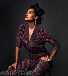 a woman sitting on top of a chair with her hands on her hips and looking up