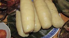 four long white breads on a plate next to other food items and plates with utensils