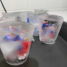 three plastic cups filled with ice and superman figures