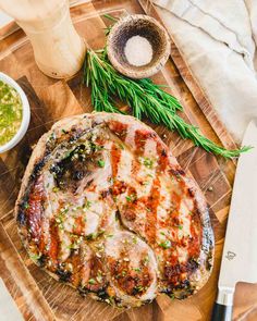 a pizza sitting on top of a wooden cutting board next to a knife and bowl