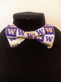 "This pre-tied and self-tie adjustable size bow tie is a perfect accent for any collared shirt! This bow tie can fit a child as young as three years old up to an adult with an 18\" neck size, even a dog or cat! *Finished print layout may vary from featured photo. **This is not a licensed product. Please note for UW, WSU, and Oregon bow ties- fabric prints have been updated as of May, 2020 The bow ties will be made with the new logo print fabrics featured in the photo next to the finished bow tie Fitted Bow Tie As A Gift, Fitted Bow Tie As Gift, Adjustable Bow Tie For Dapper Style, Adjustable Dapper Bow Tie For Father's Day, Dapper Adjustable Tie With Satin Bow, Adjustable Bow Tie For Gifts, Adjustable Satin Bow Tie As Gift, Adjustable Bow Tie For Suit As Gift, Adjustable Bow Tie Back Bow As Gift