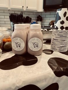 two jars sitting on top of a table covered in black and white polka dot paper