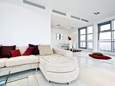 a living room filled with furniture and large windows