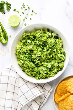 guacamole and tortilla chips in a bowl on a white table