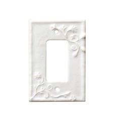 a white light switch cover with an ornate design