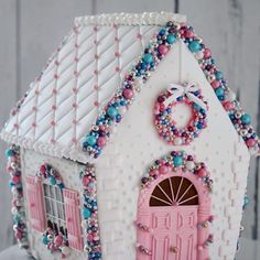 a cake shaped like a house with beads on the outside and a wreath at the top