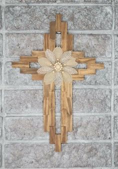 a cross made out of wood on top of a brick wall