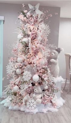 a white christmas tree with pink and silver decorations