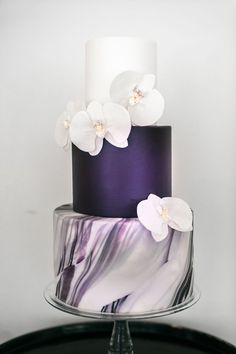 a purple and white cake with flowers on top