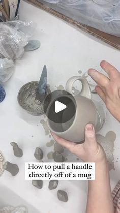 a person is pouring something into a teapot on a table with rocks and other items