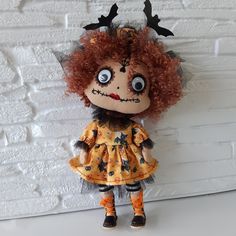 a doll with red hair wearing a dress and antlers on it's head