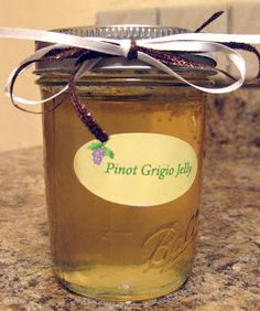 a glass jar filled with liquid sitting on top of a counter next to a white ribbon