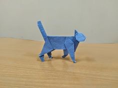 a blue origami dog standing on top of a wooden table