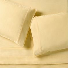 two pillows are folded on top of each other in front of a bed sheet set