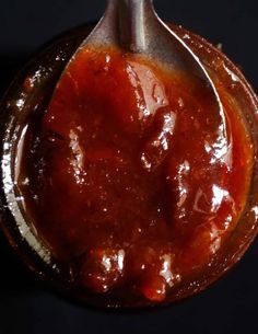 a spoon full of sauce sitting on top of a table