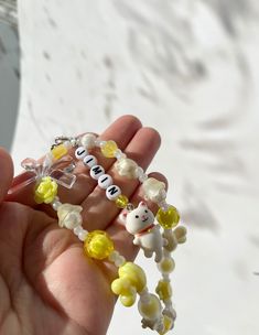 a person holding some beads in their hand with the letters spelled out on each bead