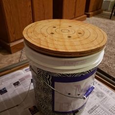 a bucket sitting on top of a floor next to a wooden cabinet and carpeted area