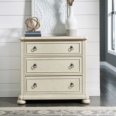 a white dresser with two vases on top of it