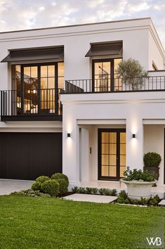 a white two story house with black doors and windows