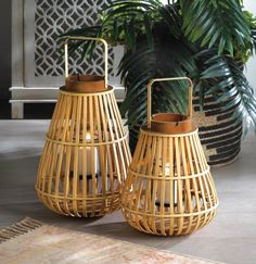 two bamboo baskets sitting on top of a rug next to a potted palm tree